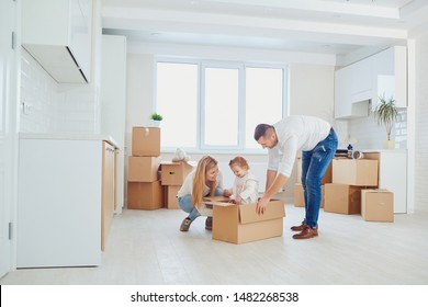 Happy Family Unpacking Boxes At New Home