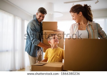Happy family unpacking boxes in new home on moving day