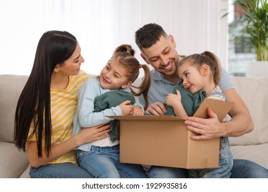 Happy Family Unpacking Moving Box At Their New House