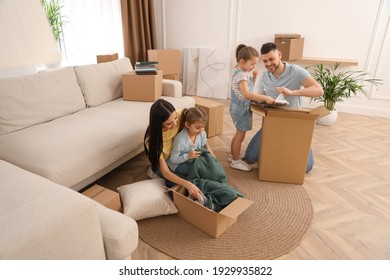 Happy family unpacking moving boxes at their new house - Powered by Shutterstock