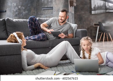 Happy Family Using Digital Devices At Home 
