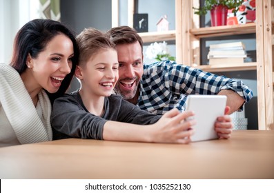 Happy Family Using Digital Tablet Together At Home