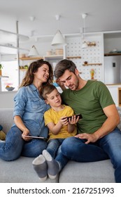 Happy Family Using Digital Technology Decives For Playing Watching Movies, Relaxing At Home.