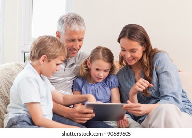 Happy Family Using A Tablet Computer In A Living Room