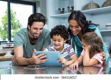 Happy family using tablet in the kitchen at home