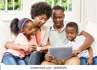 Happy family using tablet on the sofa at home