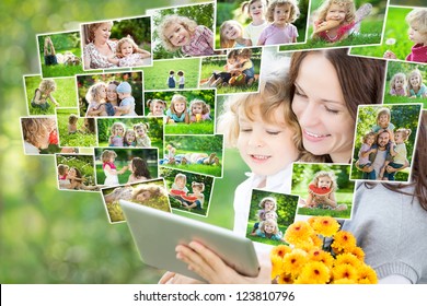 Happy Family Using Tablet PC Outdoors In Spring Park