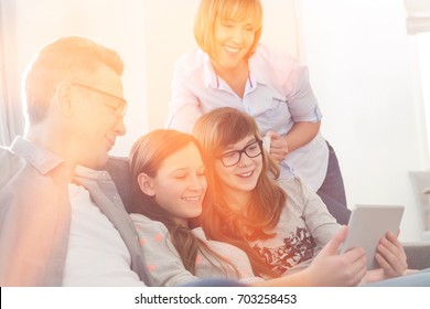 Happy Family Using Tablet PC On Sofa At Home