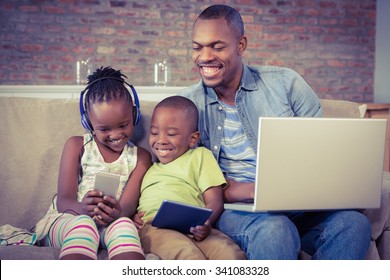 Happy family using technology together in living room