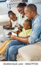 Happy Family Using Technology Together In Living Room