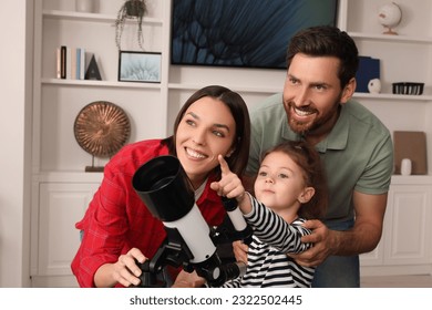Happy family using telescope to look at stars in room - Powered by Shutterstock