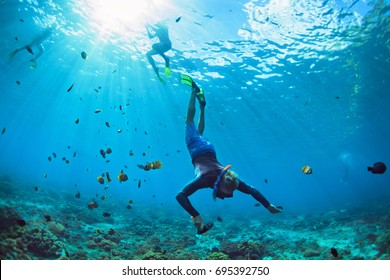 Happy family vacation  Man in snorkeling mask and camera dive underwater and tropical fishes in coral reef sea pool  Travel lifestyle  water sport outdoor adventure  swimming summer beach holiday