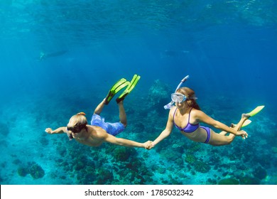 Happy family vacation. Young couple in snorkeling mask hold hand, free dive underwater with fishes in coral reef sea pool. Travel lifestyle, watersport adventure, swim activity on summer beach holiday