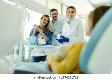 Happy Family At Visit In The Dentist Office.