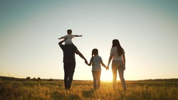 Happy Family Walk In Field In Nature.Parents And Children Are Free And Active People In Nature.Healthy And Cheerful Family At Picnic In The Park.Summer Walk In The Park At Sunset.Parents And Children