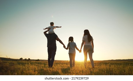 Happy family walk in field in nature.Parents and children are free and active people in nature.Healthy and cheerful family at picnic in the park.Summer walk in the park at sunset.Parents and children - Shutterstock ID 2179239729