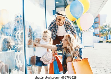 Happy Family Walking Along The Shopping Mall.