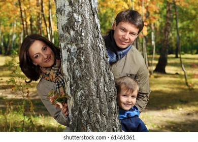 Happy Family Walking At The Autumn Park.