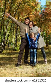 Happy Family Walking At The Autumn Park.