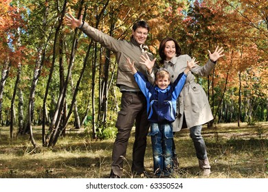 Happy Family Walking At The Autumn Park.