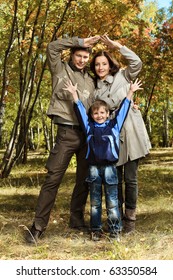 Happy Family Walking At The Autumn Park.