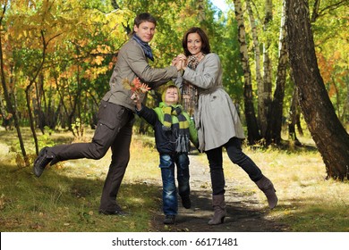 Happy Family Walking At The Autumn Park.