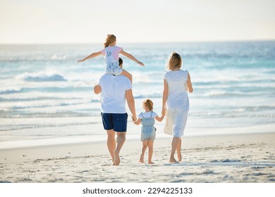 Happy family walking the beach. Rear view of young parents with children having fun on vacation. Little boy and girl enjoying summer with mother and father