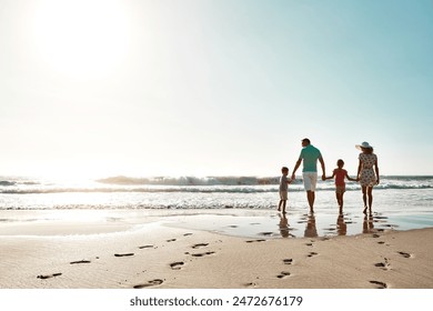 Happy family, walking and holding hands at beach in summer for relax, travel and holiday in Miami. Parents, children and people at ocean with back for vacation, bonding and trust together by water - Powered by Shutterstock