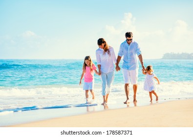 Happy Family Walking On The Beach