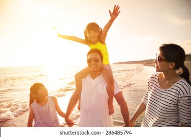 Happy Family Walking On The Beach