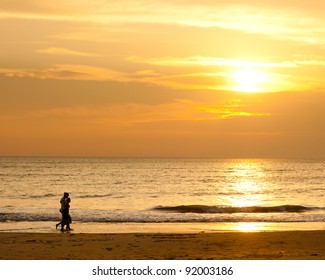 Happy family walking on the beach at sunrise for holiday time - Powered by Shutterstock