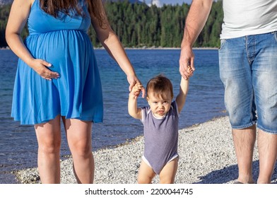 Happy Family Walking On Lakeside With Baby Boy Toddler Infant.pregnant Woman Expecting Second Baby.man Woman Hold Child From Hands Lift Up Let Him Down.mountains,family Time