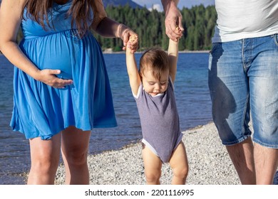 Happy Family Walking On Lakeside With Baby Boy Toddler Infant.pregnant Woman Expecting Second Baby.man Woman Hold Child From Hands Lift Up Let Him Down.mountains,family Time.angry Face Toddler Emotion