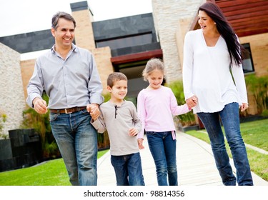 Happy Family Walking Outside Their Home And Smiling