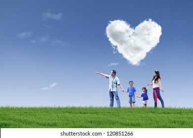 Happy family walking in the park with cloud of love in the sky - Powered by Shutterstock