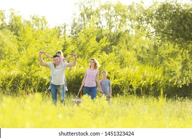 Happy Family Walking In Park On Summer Day