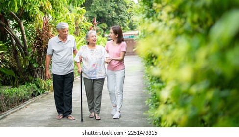 Happy family walking together in the garden. Old elderly using a walking stick to help walk balance. Concept of  Love and care of the family And health insurance for family - Powered by Shutterstock