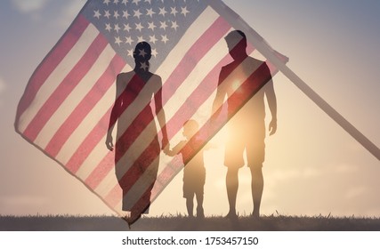 Happy family walking together at sunset holding hands agains the flag of America USA background. Double exposure
 - Shutterstock ID 1753457150