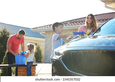 Happy family washing car at backyard on sunny day - Powered by Shutterstock