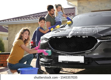 Happy family washing car at backyard on sunny day - Powered by Shutterstock