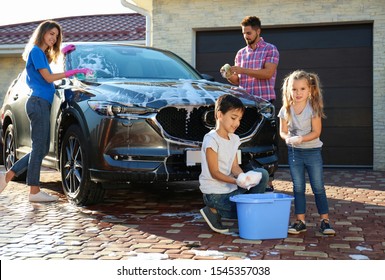 Happy family washing car at backyard on sunny day - Powered by Shutterstock