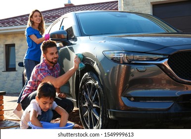 Happy family washing car at backyard on sunny day - Powered by Shutterstock