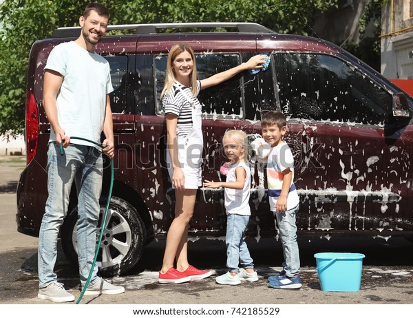Happy family washing car\
outdoors