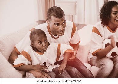 Happy Family Watching A Football Match At Home