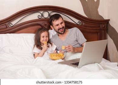 Happy Family Watching Movie In Bed And Eating Chips.