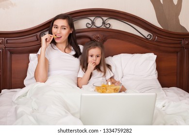 Happy Family Watching Movie In Bed And Eating Chips.