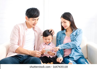 Happy Family Watching The Smart Phone  On Sofa