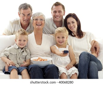 Happy Family Watching Television And Eating Chips At Home