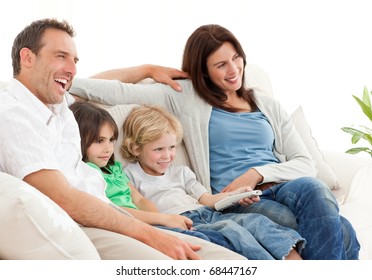 Happy family watching television together on the sofa