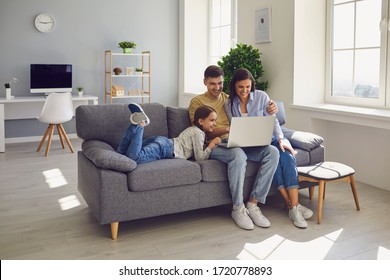 Happy Family Watching Together Video Online In A Laptop While Sitting Comfortably At Home.